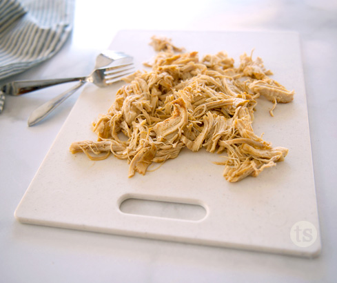 shredded chicken on cutting board