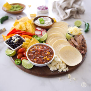 Charcuterie board with Mexican night with meat, vegetables and toppings