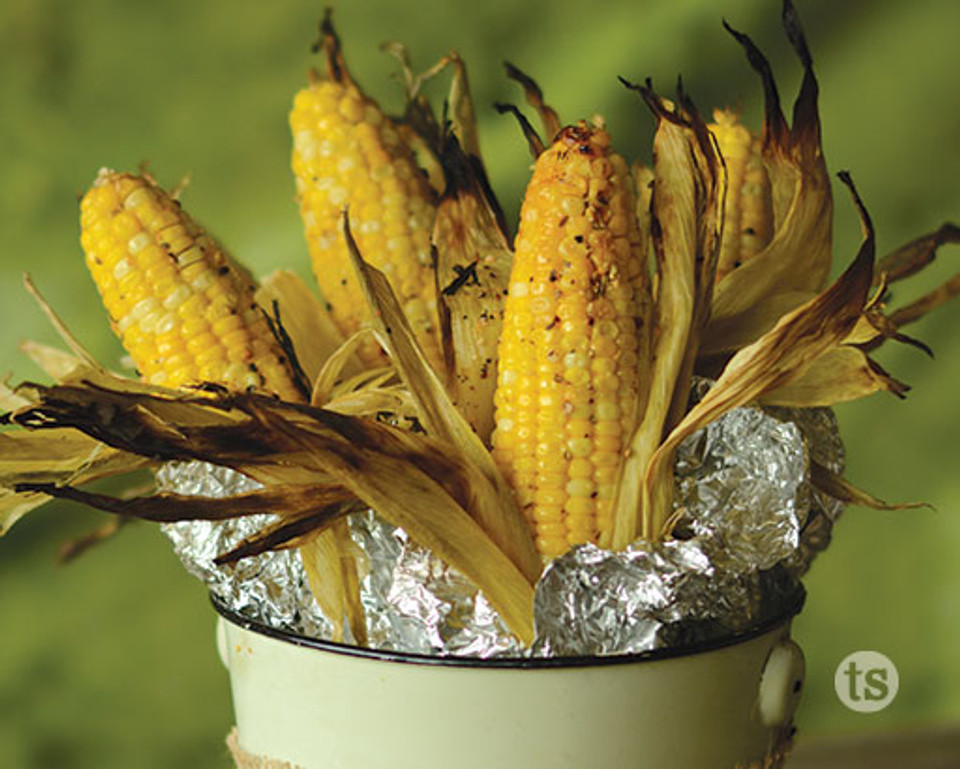 Try these fire roasted ears of corn wrapped in foil and standing upright in a bucket