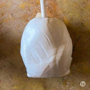 Step three to make Cookie Dough Ghost Pops. Dip into melted almond bark.