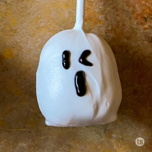 Step four to make Cookie Dough Ghost Pops. Draw face on ghost with black decorating gel.