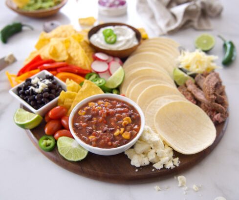 Charcuterie board with Mexican night with meat, vegetables and toppings